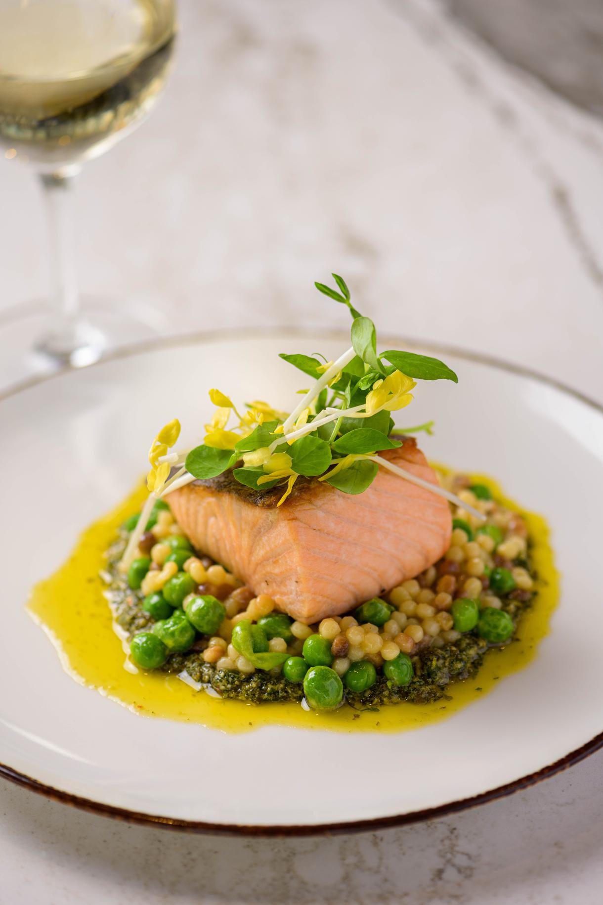 Fresh salmon crowns a bed of Sardinian pasta, peas, and basil pesto. Photo by Chris Schmauch.