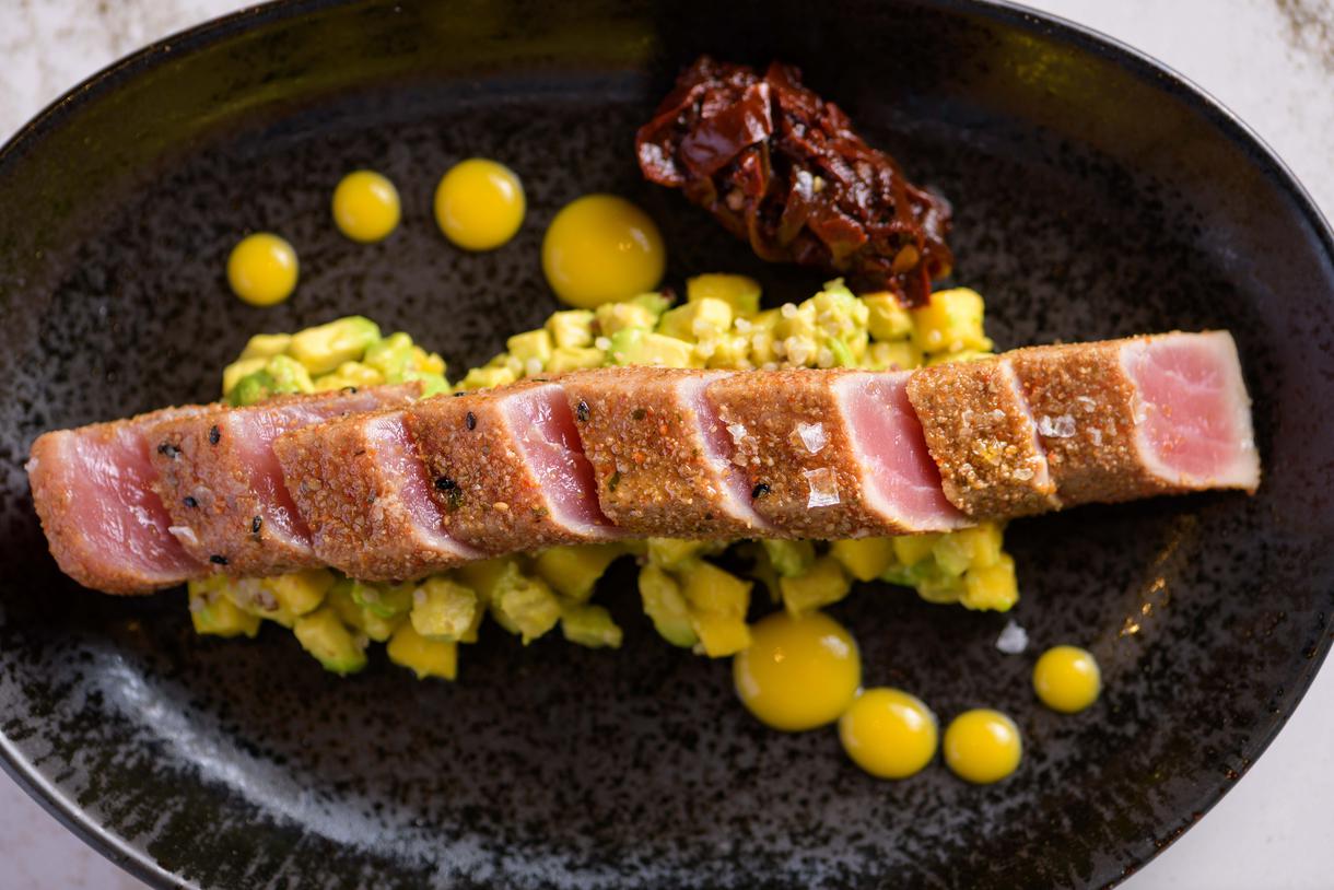 The seared ahi tuna arrives atop a medley of crispy quinoa, mango, and avocado. Photo by Chris Schmauch.