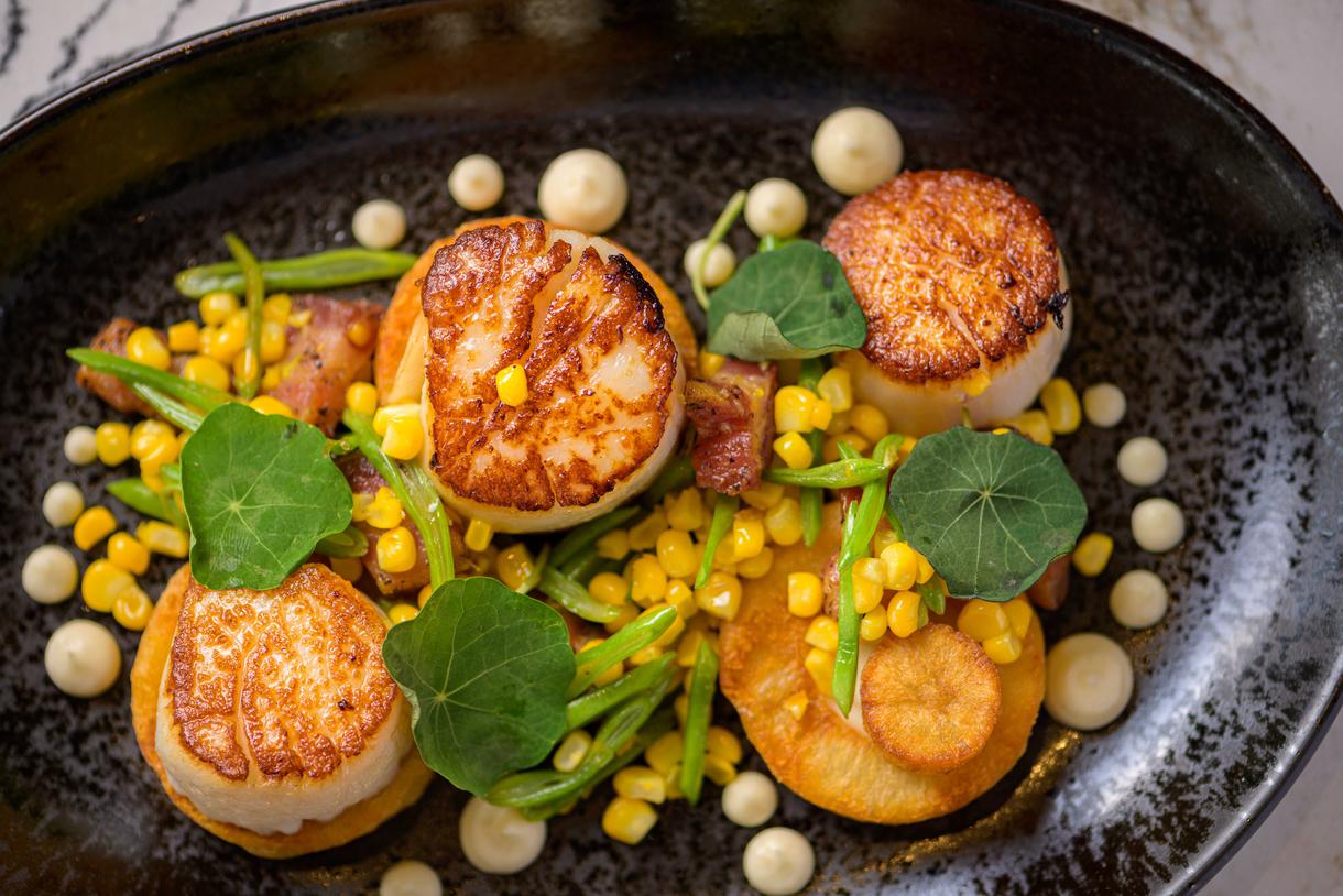 Perfectly seared sea scallops are enhanced only by sweet corn kernels and crispy pancetta. Photo by Chris Schmauch.
