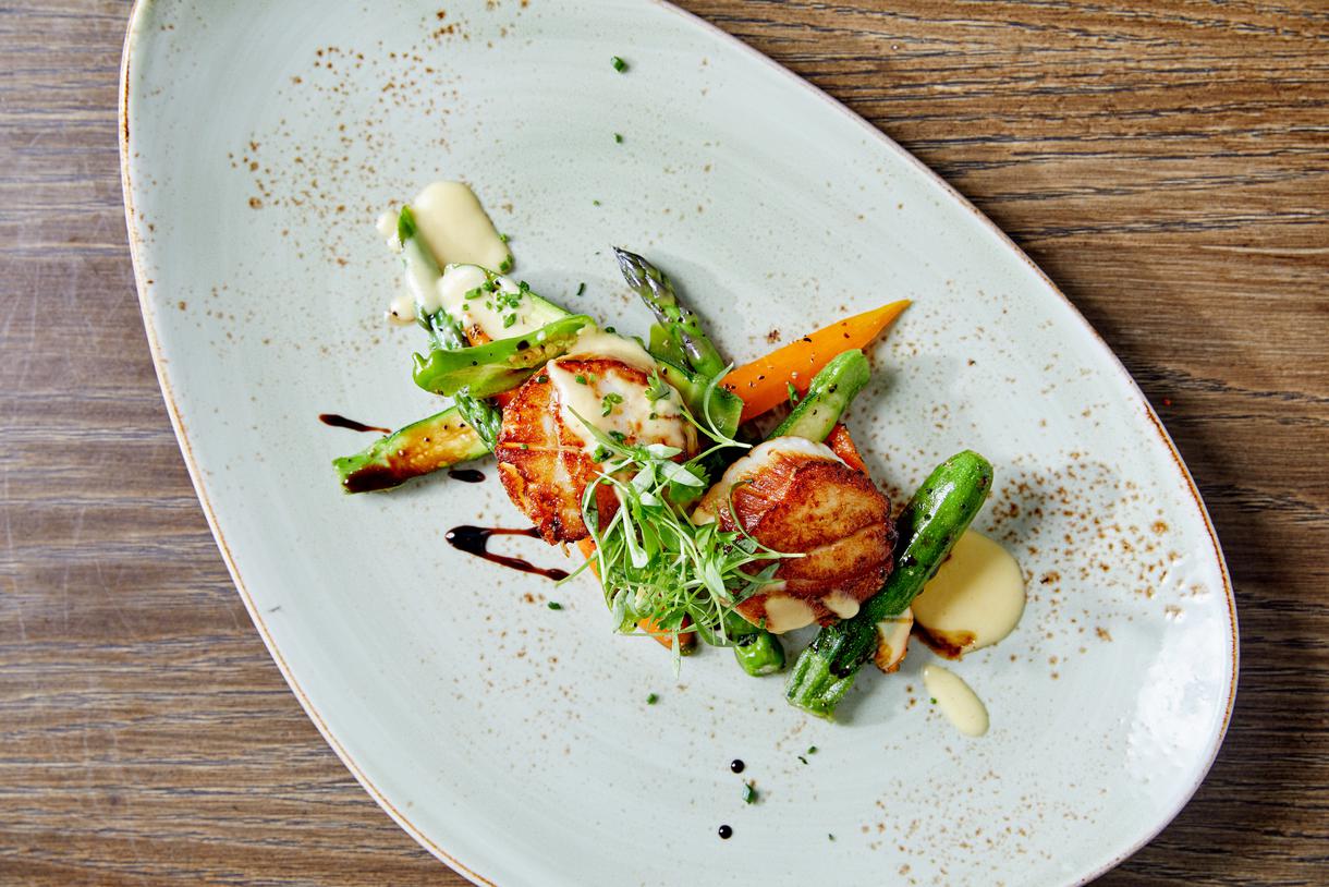Seared diver scallops are intermingled with seasonal vegetables and miso and lima bean puree.