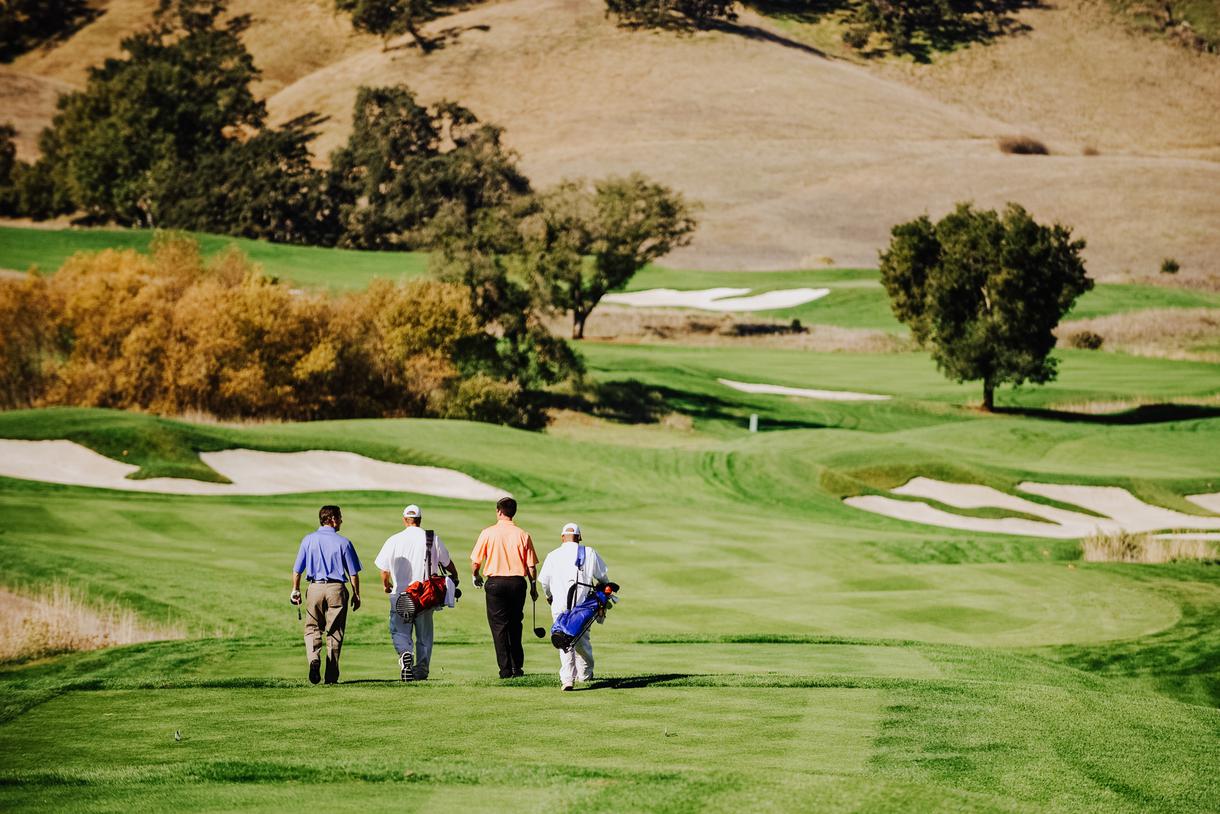 Golfers walk the fairway